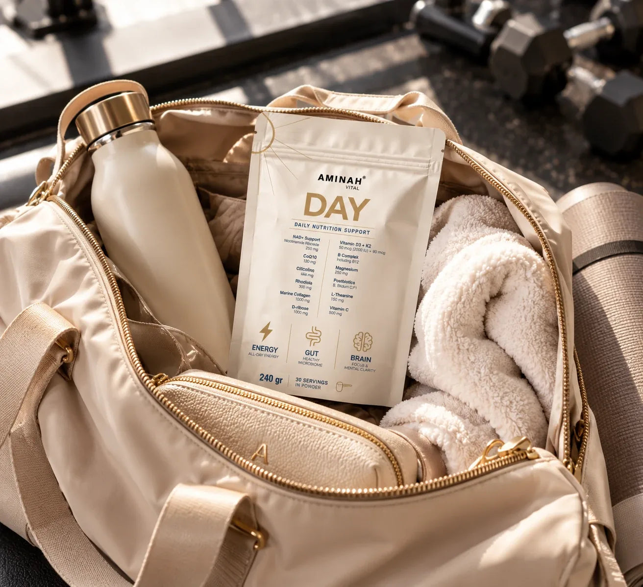 Envase de AMINAH DAY en una bolsa de deporte, junto a una botella de agua y una toalla