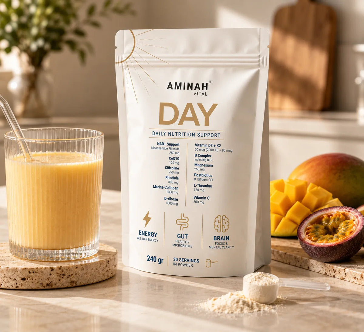 AMINAH DAY pouch beside a glass of Mango & Passion Fruit drink and fresh mango